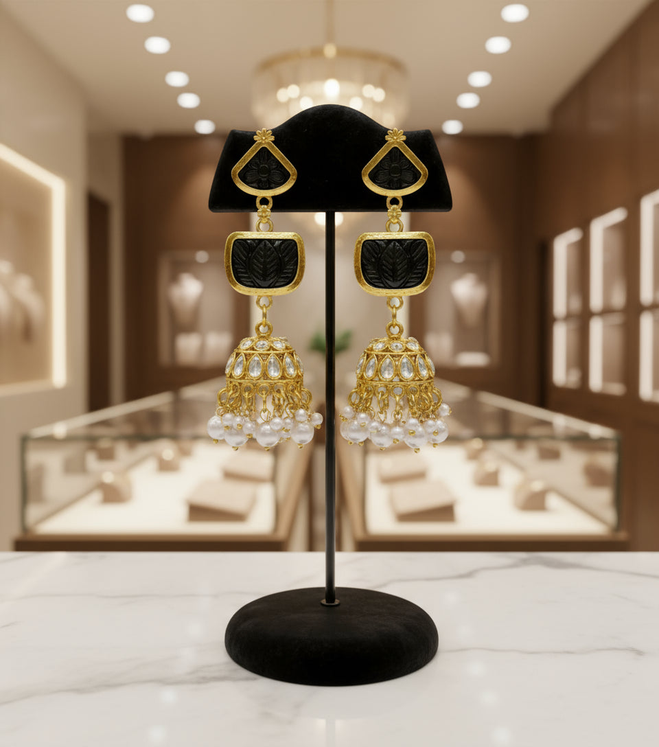 A pair of gold-plated sugar stone drop jhumka earrings with pink stones and white pearl-like accents.