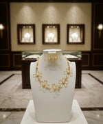 three-piece flower choker necklace set displayed on a black mannequin, consisting of a choker necklace and matching earrings with gold-coloured floral designs and pearl studs.