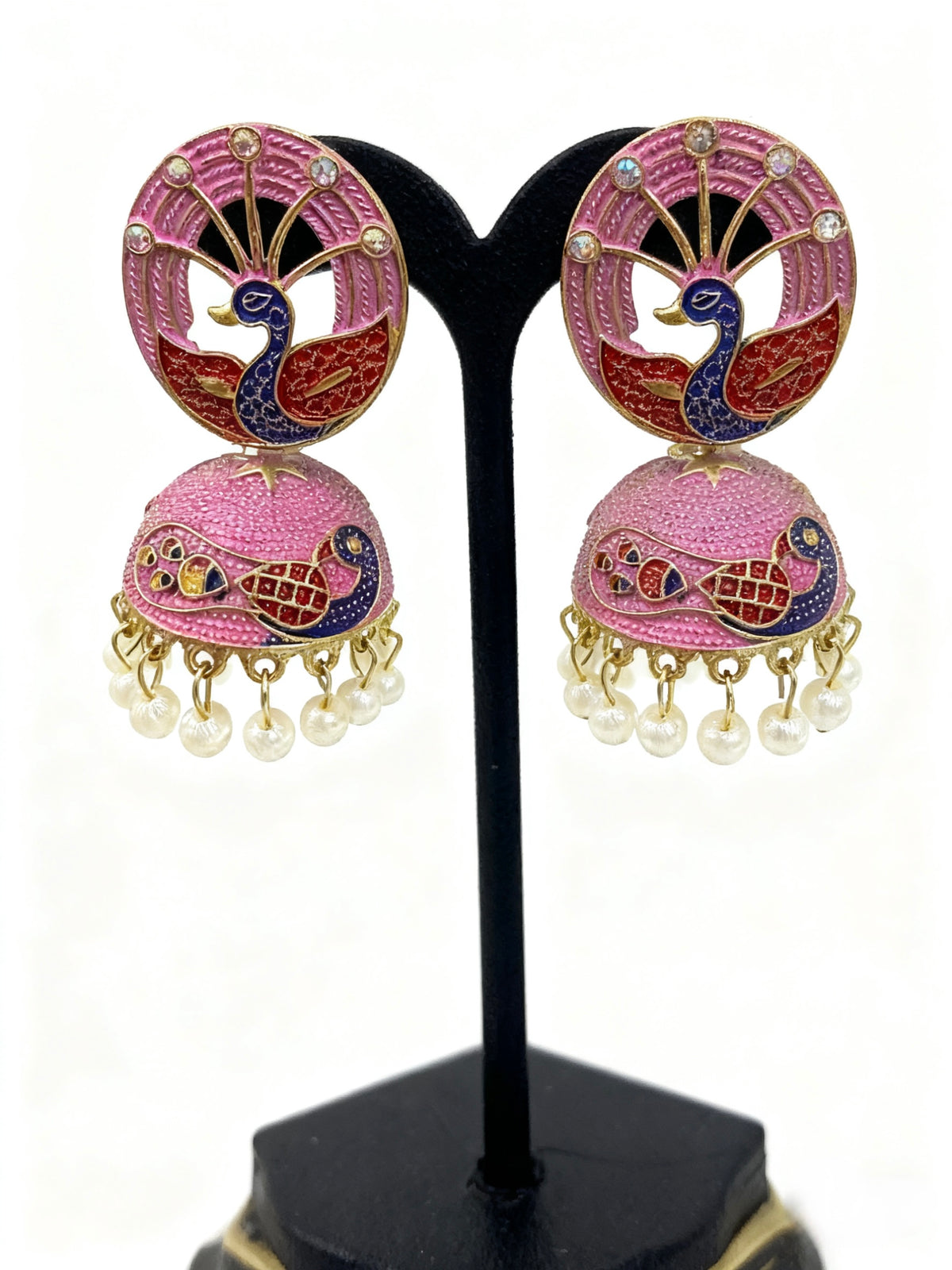 Pair of pink peacock earrings with pearl details on a black stand.