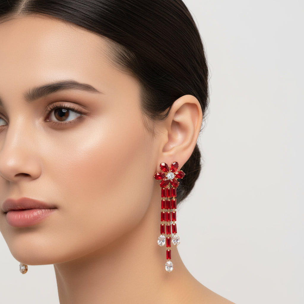 A pair of silver finish cubic zirconia flower drop earrings displayed on a stand, featuring a series of connected stones and flowers.