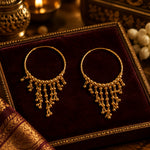 Pair of 22K gold-plated beaded tassel hoop earrings with delicate cascading fringe, displayed on soft cream satin — premium Pakistani ethnic jewellry.