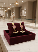 A pair of gold-plated Mona Lisa pendulum earrings featuring green stones and silver pearls.