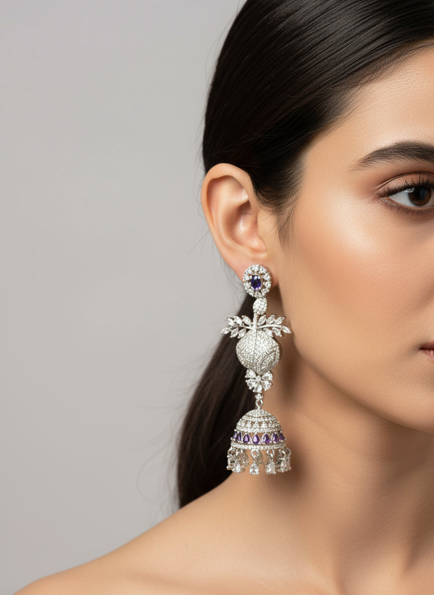 Woman wearing large, ornate earrings against a dark background