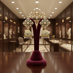 A pair of gold-plated brass Meenakari stud Jhumka earrings with green and white stones.