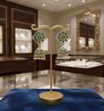 A pair of gold-plated brass Meenakari stud Jhumka earrings with green and white stones.