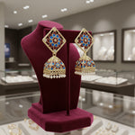 A pair of gold-plated brass Meenakari stud Jhumka earrings with green and white stones.