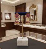 A pair of gold-plated brass Meenakari stud Jhumka earrings with green and white stones.