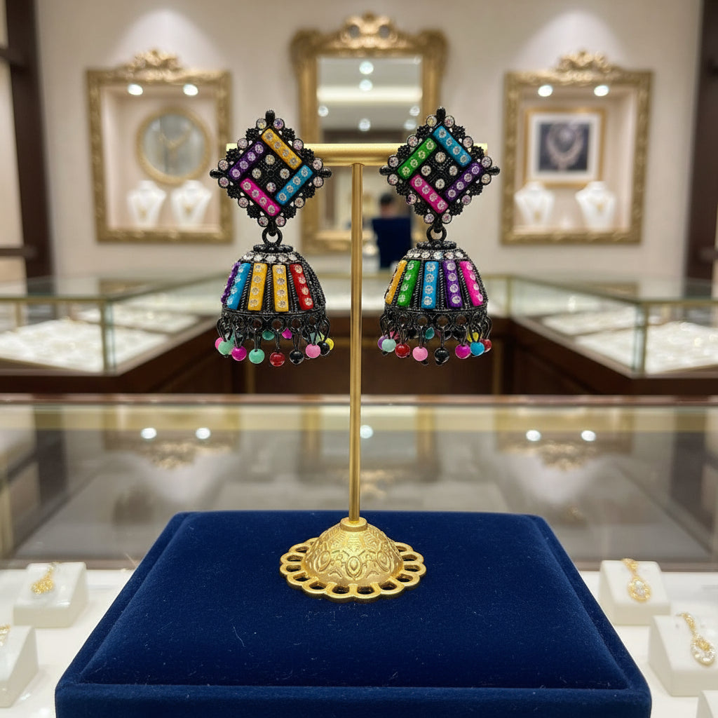 A pair of black multi-colored stone earrings on a stand, featuring a geometric pattern and dangling with small beads.