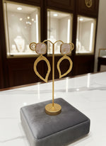 Gold earrings on a stand