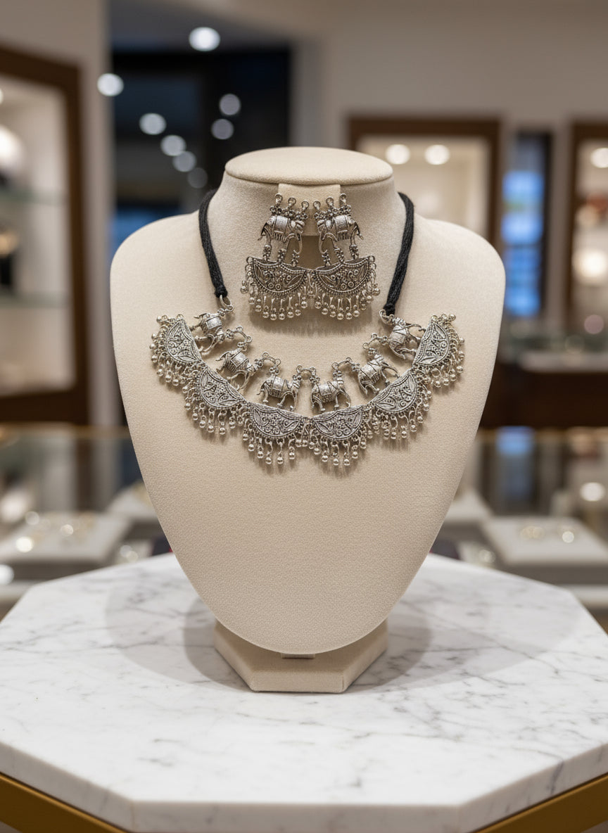 Silver jewellery set on a black stand with a blurred background