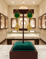 A pair of gold-colored filigree earrings featuring round yellow stones at the center, presented against a white background.