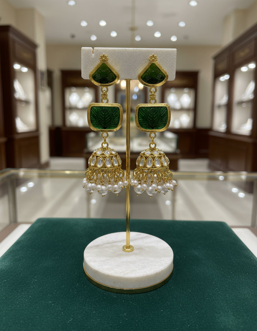 A pair of gold-plated sugar stone drop jhumka earrings with pink stones and white pearl-like accents.