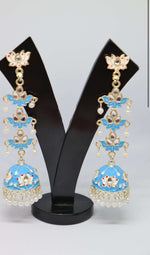 A pair of silver-plated tulip-shaped long jhumka earrings with multicolor details, displayed on a black stand.