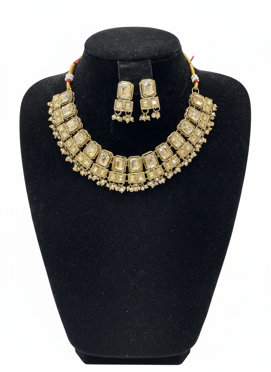Gold necklace and earrings set on a black bust