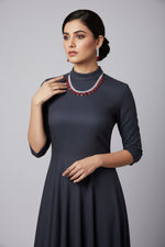 A black mannequin showcasing a luxury choker necklace set with blue and white stones, accompanied by matching earrings.