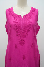 A bright magenta pink sleeveless kurta with floral embroidery on the chest and scattered embroidered motifs across the fabric, hanging on a white hanger.