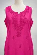 A bright magenta pink sleeveless kurta with floral embroidery on the chest and scattered embroidered motifs across the fabric, hanging on a white hanger.
