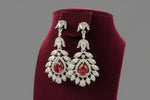 A earrings stand with leaf designs, featuring American diamonds and hot pink semi-precious stones. Party wear earrings.