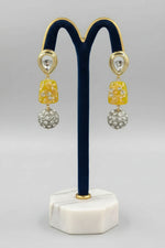 A gold-plated Kundan-studded and pearl-beaded handcrafted earrings, displayed against a black background. Party wear set.