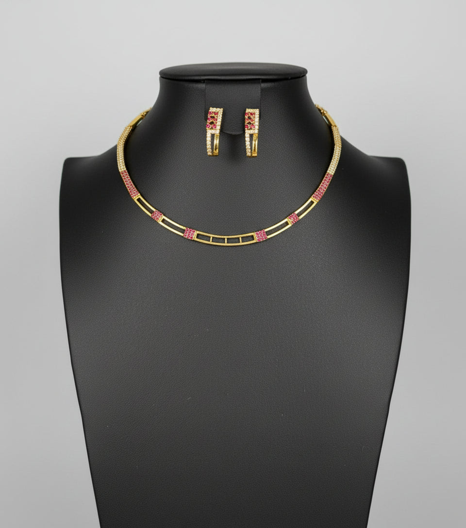 A gold-tone Hasli necklace set with American diamonds and semi precious ruby stones, displayed on a mannequin neck.