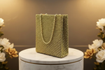 A gold rectangular handcrafted tote bag with glass beads and silk base, displayed against a black background.