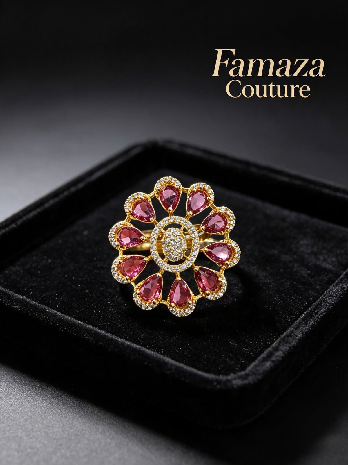 A gold ring with pink gemstone accents arranged in a floral pattern, displayed on a black velvet jewelry box. The brand name 'Famaza Couture' is visible in the top right corner.