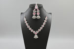 A mannequin showcasing a silver plated necklace set with pink and white stones, accompanied by earrings and a maang tikka. Party wear set.