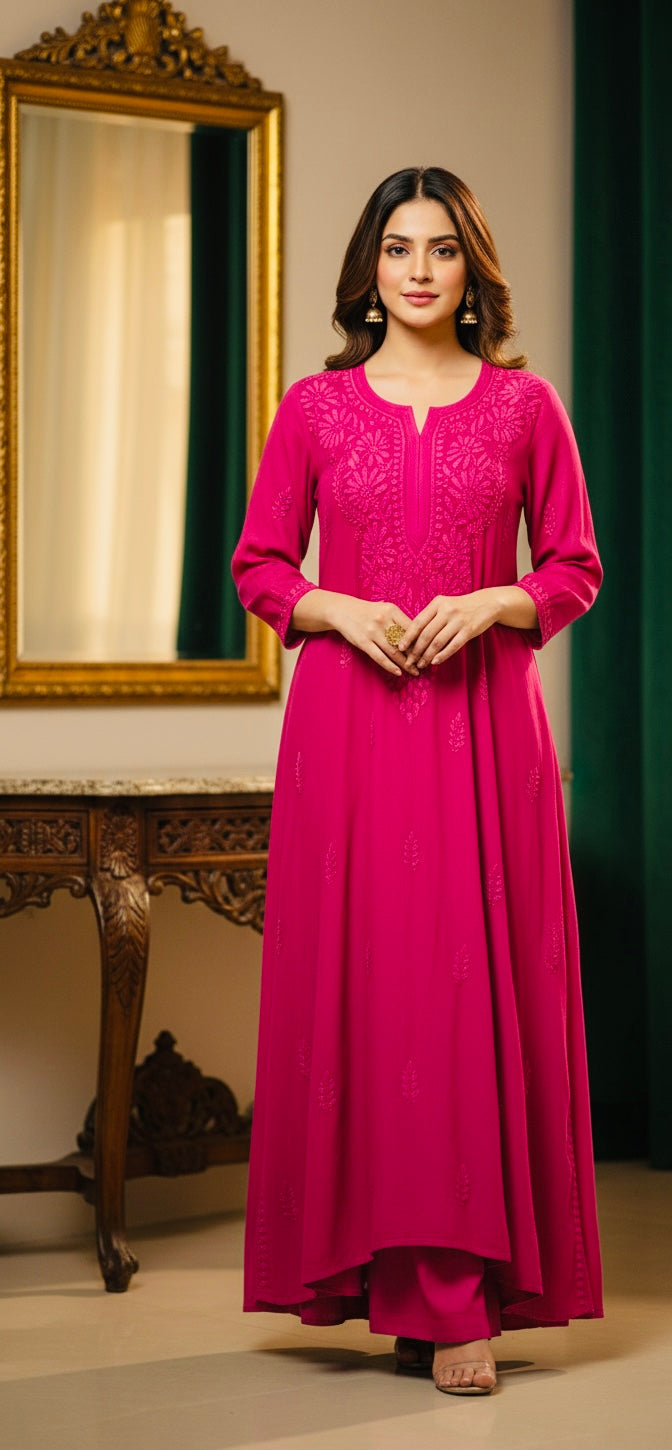 Woman in a pink traditional outfit standing in a room with a mirror and decorative items.
