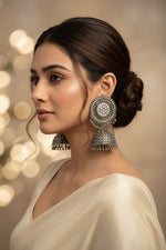 A model wearing posh black oxidised jhumke with an elegant evening gown, showcasing luxury party wear jewellery for a sophisticated English style look.