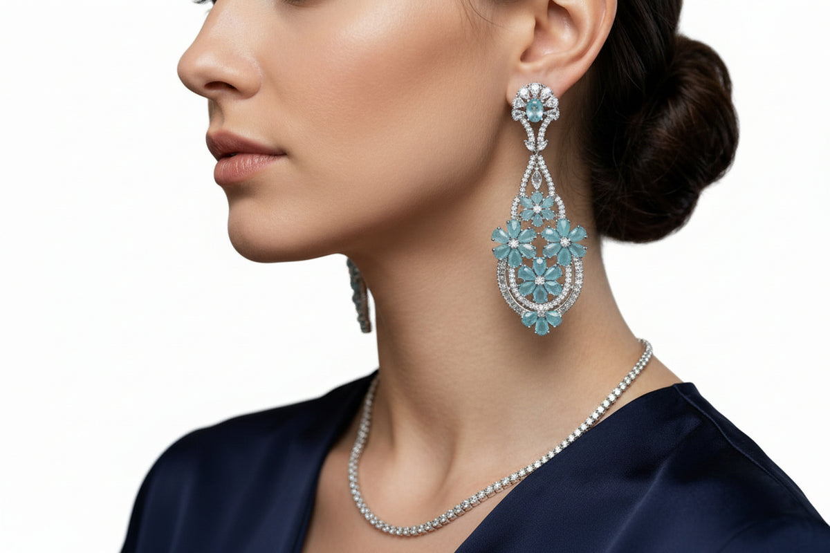 A model wearing radiant teal floral gala chandelier earrings close up image.