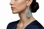 A model wearing radiant teal floral gala chandelier earrings close up image.