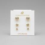 A pack of three pairs of golden heart-shaped stud earrings in graduated sizes, each featuring a central crystal.