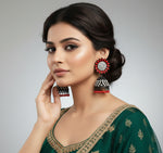 A pair of black Jhumki earrings with sunflower designs, featuring red and silver multi shade stones and sky blue nano hangings.