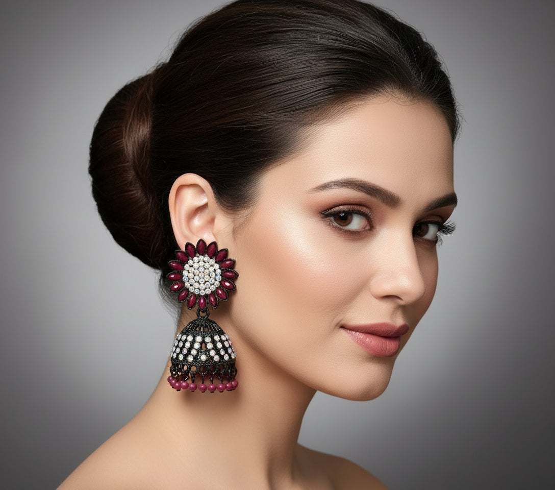 A pair of black base metal Jhumki earrings with sunflower designs, featuring maroon and silver multi shade stones and sky blue nano hangings.
