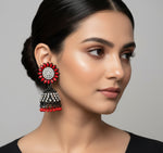 A pair of black base metal Jhumki earrings with sunflower designs, featuring red and silver multi shade stones and sky blue nano hangings.