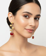 A pair of gold-plated Monalisa red stone earrings with golden coin details.