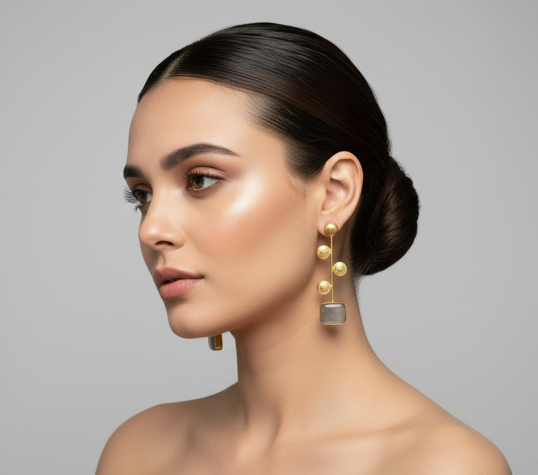 A pair of gold-plated earrings with grey Monalisa stone and coin details.