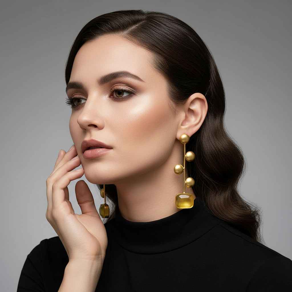 A pair of gold-plated earrings with yellow Monalisa stone and coin details.