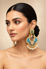 A pair of gold-toned chandbali earrings with blue and black minakari and kundan studded details along with pearls.