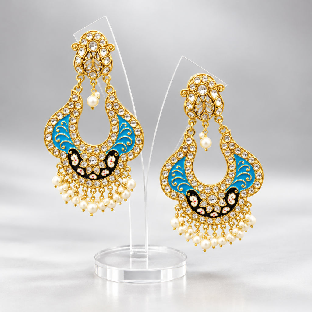 A pair of gold-toned chandbali earrings with blue and black minakari and kundan studded details along with pearls. Party wear.