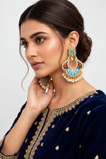 A pair of gold-toned chandbali earrings with blue meenakari and kundan studded details along with pearls.