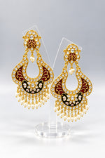 A pair of gold-toned chandbali earrings with maroon and black minakari and kundan studded details along with pearls. Party wear.