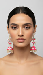 A pair of hot pink colour silver-plated tulip-shaped long jhumka earrings with multicolour details, displayed on a black stand.