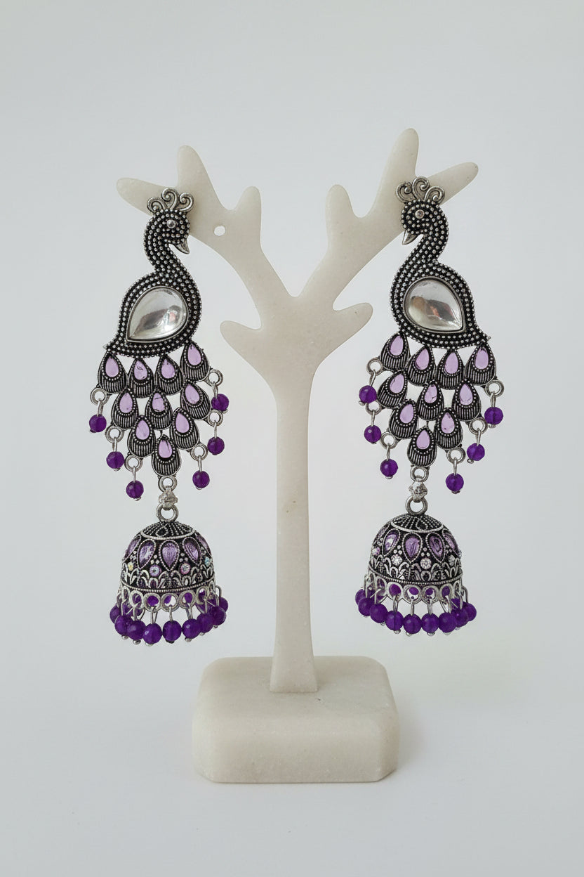 The Royal Mayura oxidised peacock figure jhumka earrings with beaded accents by Famaza Couture.