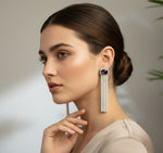 A pair of silver finish cubic zirconia drop earrings with Purple doublet semi precious stones. Party wear earrings.