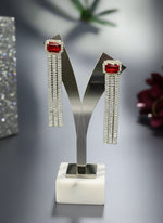 A pair of silver finish cubic zirconia drop earrings with red doublet semi precious stones. Party wear earrings.