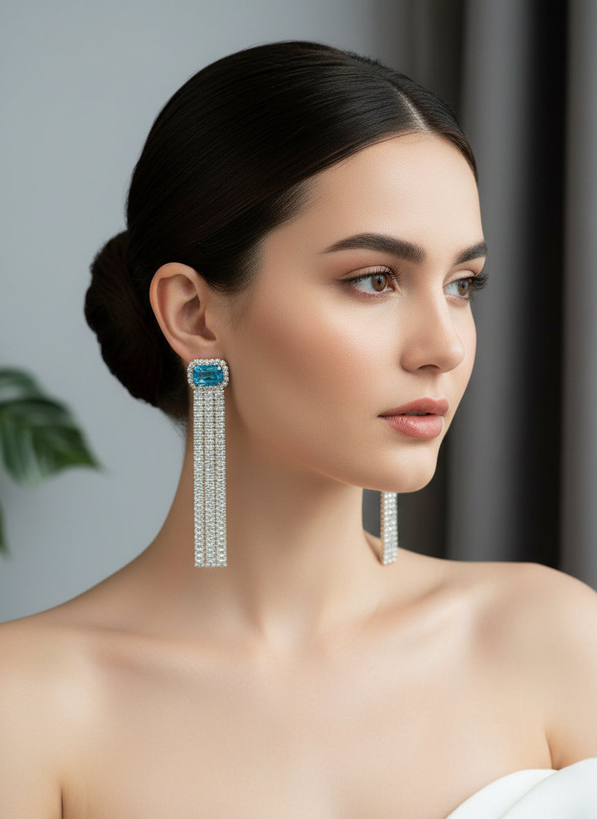 A pair of silver finish cubic zirconia drop earrings with sky blue doublet semi precious stones. Party wear earrings.