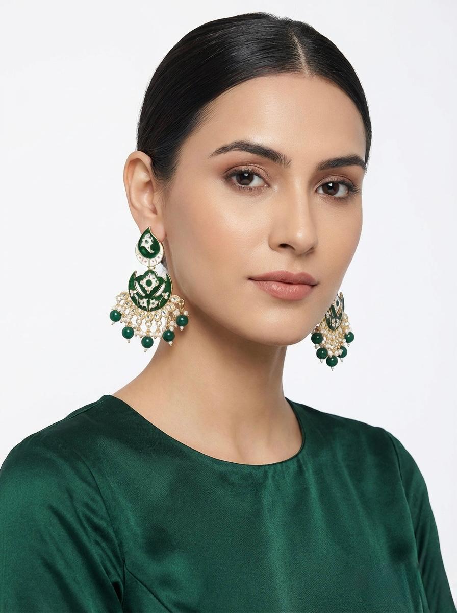 A pair of statement drop earrings on our model featuring large emerald green square and teardrop stones.