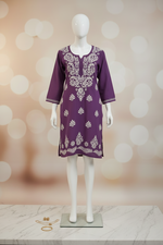 A purple long-sleeve tunic top with white floral block prints, hanging on a wooden hanger against a plain white background.