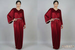 A red velvet kaftan dress displayed on a mannequin, featuring a batwing sleeve design and a V-neckline.